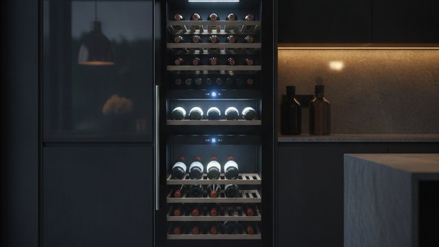 Glass fronted wine cooler filled with bottles in a kitchen